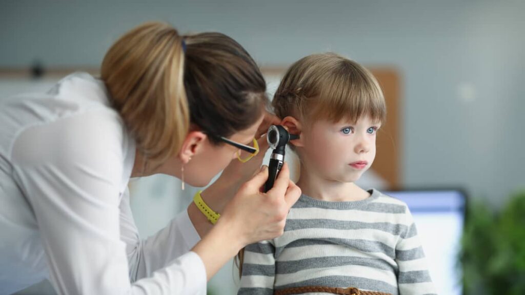 medicul ORL pediatru examineaza urechea unei fetite